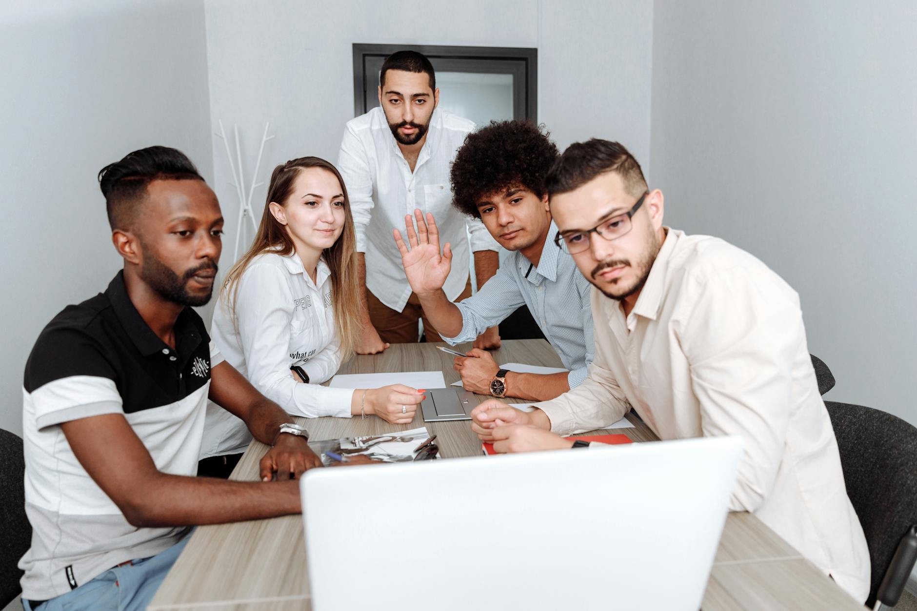 A Group of People Sitting on the Chair while Communicating on Laptop