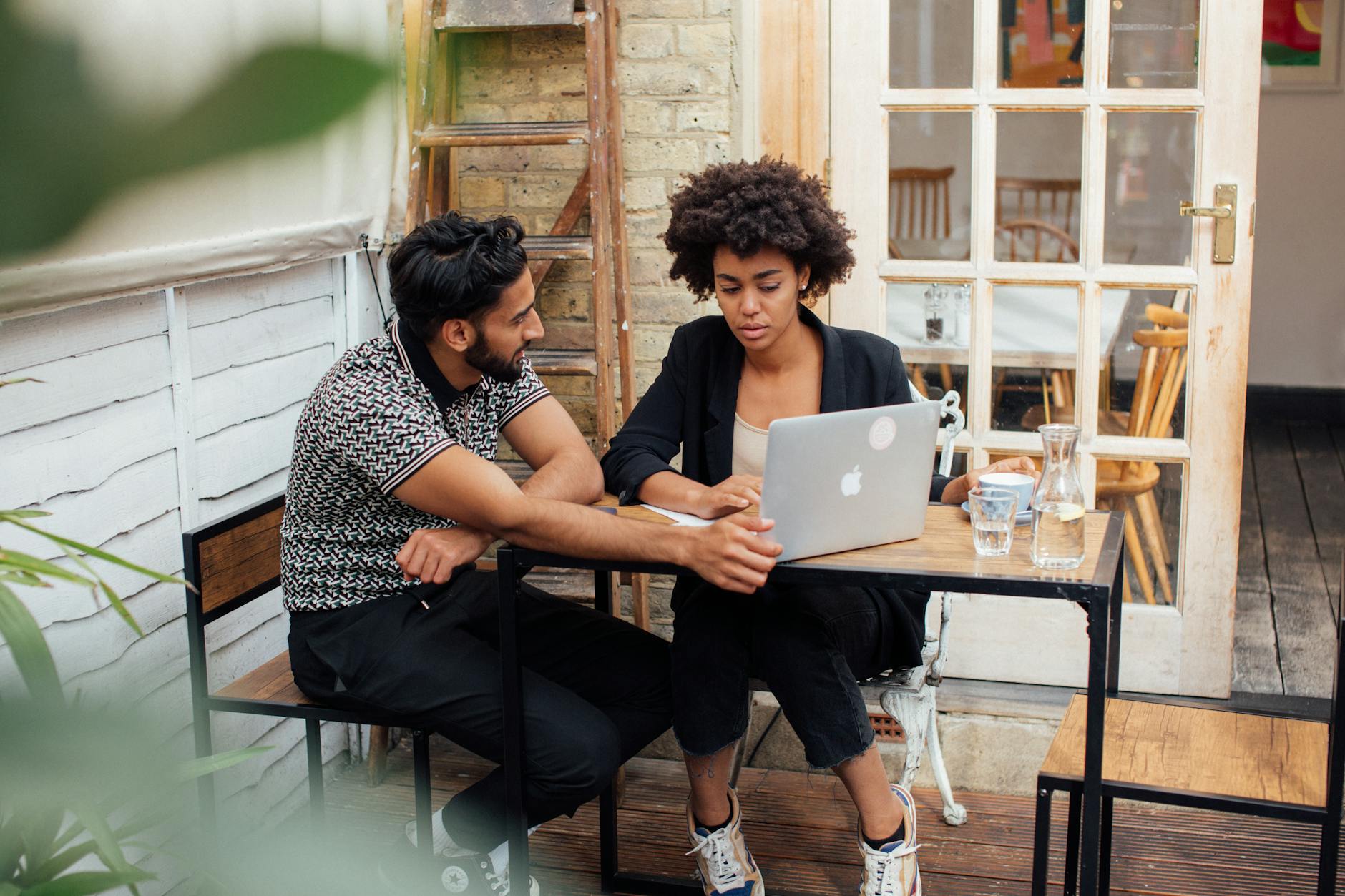 Couple Sitting by the Table with a Laptop