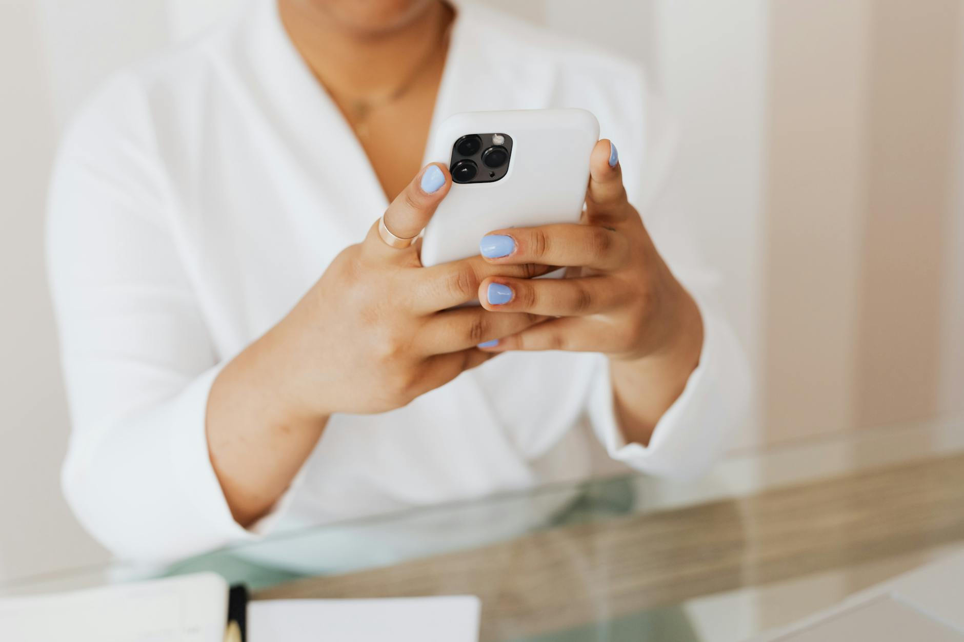 Person in White Top Using a Cellphone