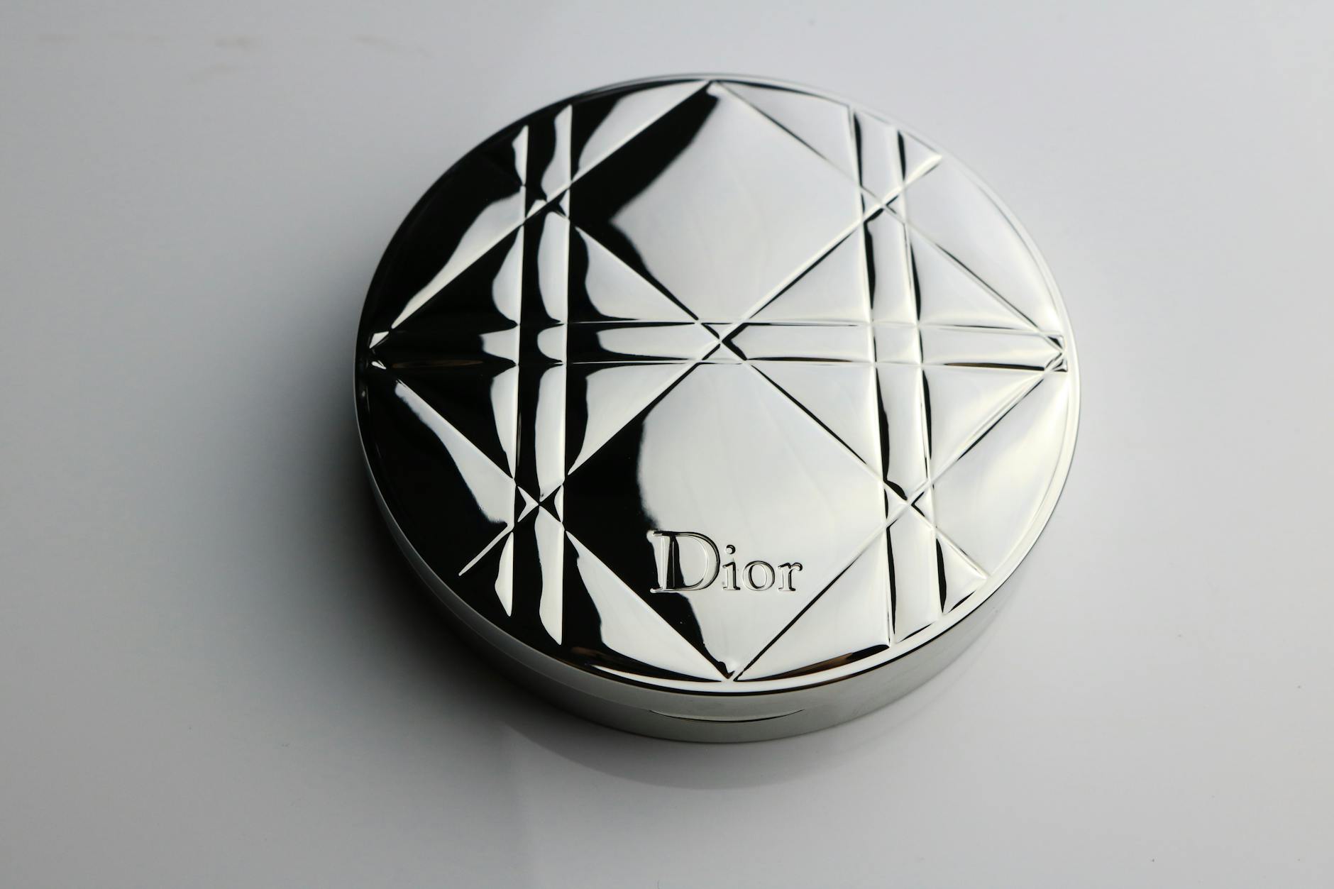 A Shiny Compact Makeup Powder Case on a Flat Surface