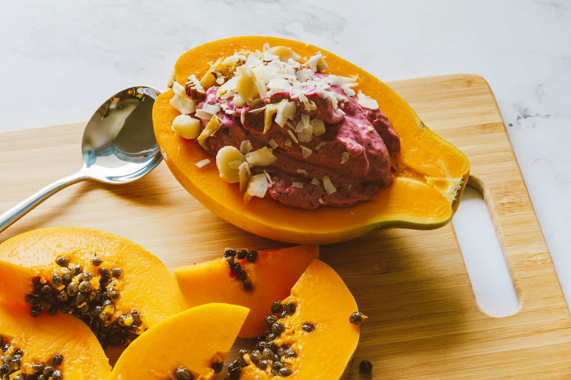 Close-Up Shot of Slices of Papaya on a Wooden Chopping Board