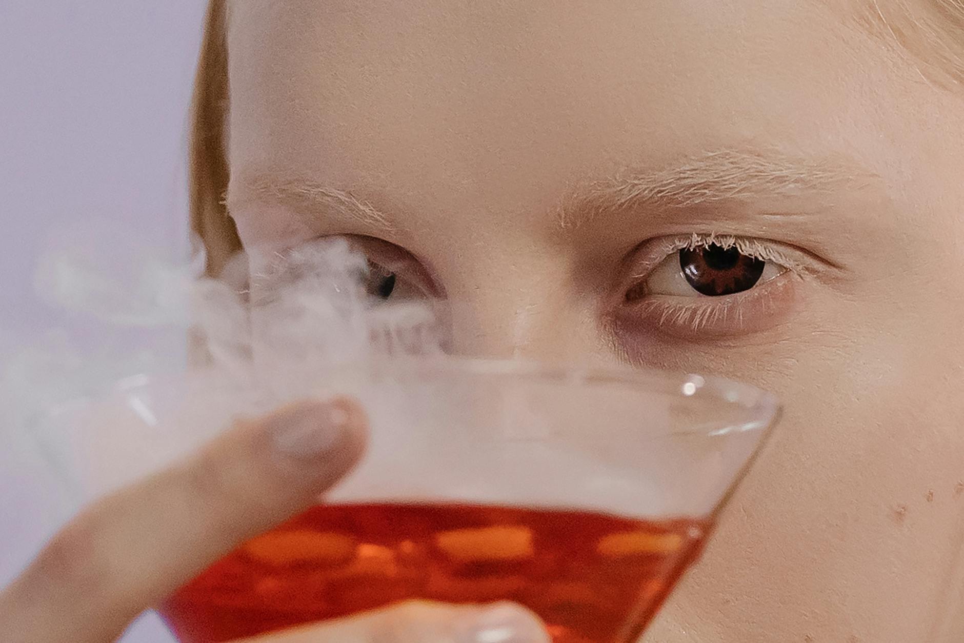 Woman Holding Clear Drinking Glass With Red Liquid