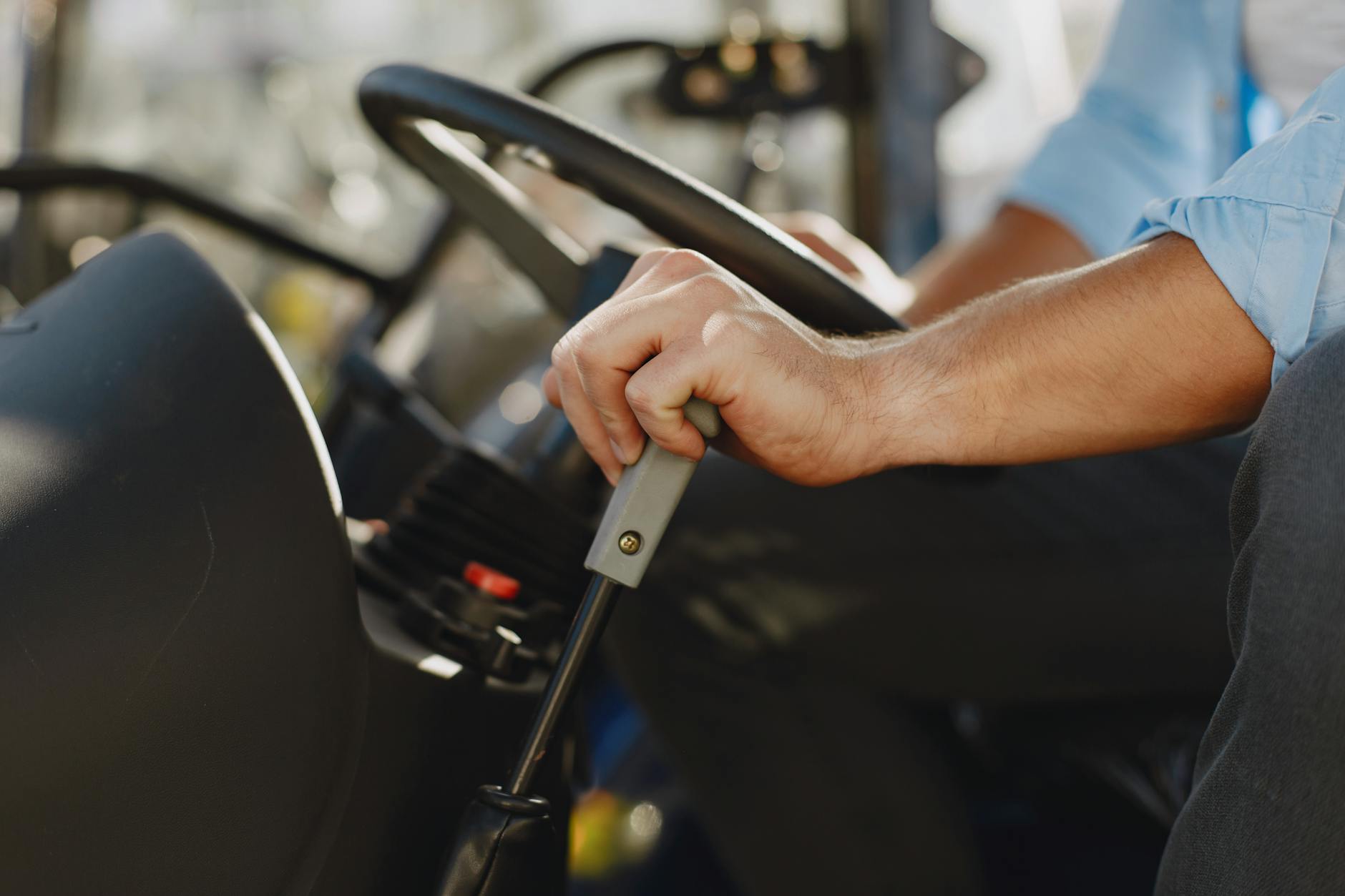 Close up of a Steering Wheel and Mans Hand on a Gear