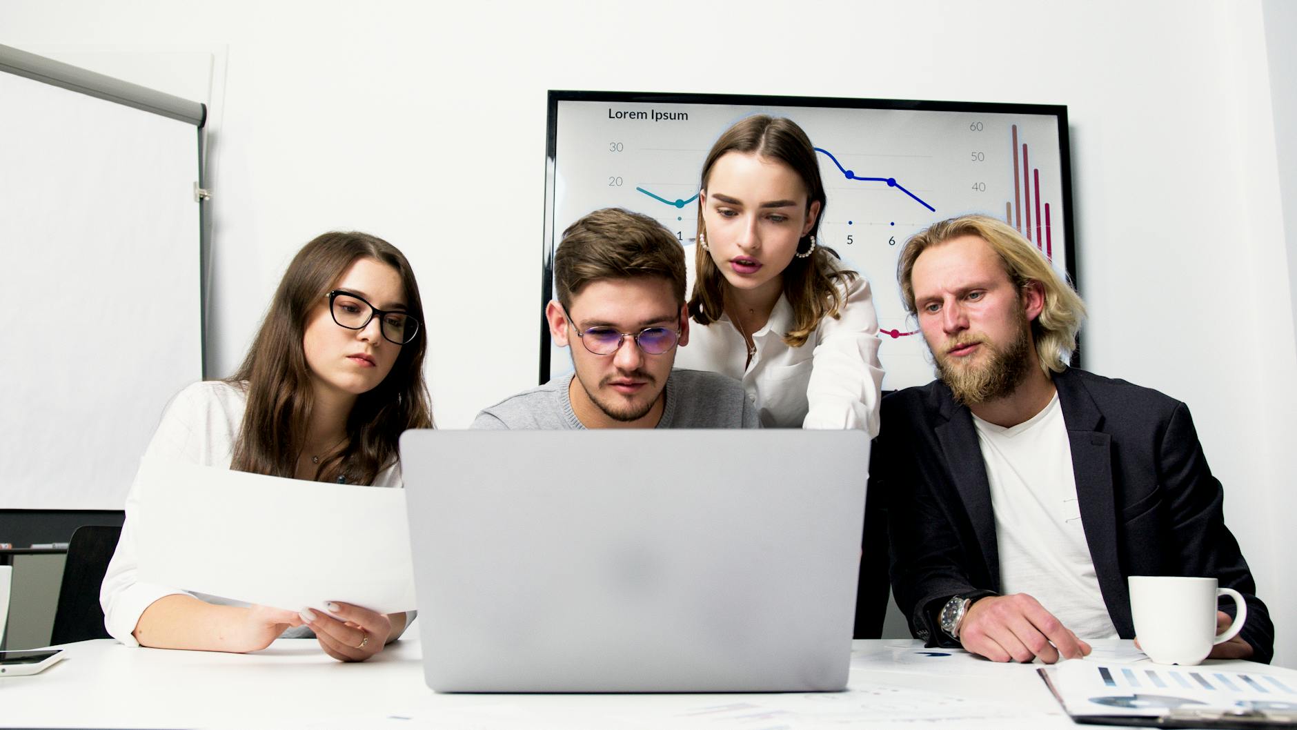 A Group of People Working Together Looking at a Laptop