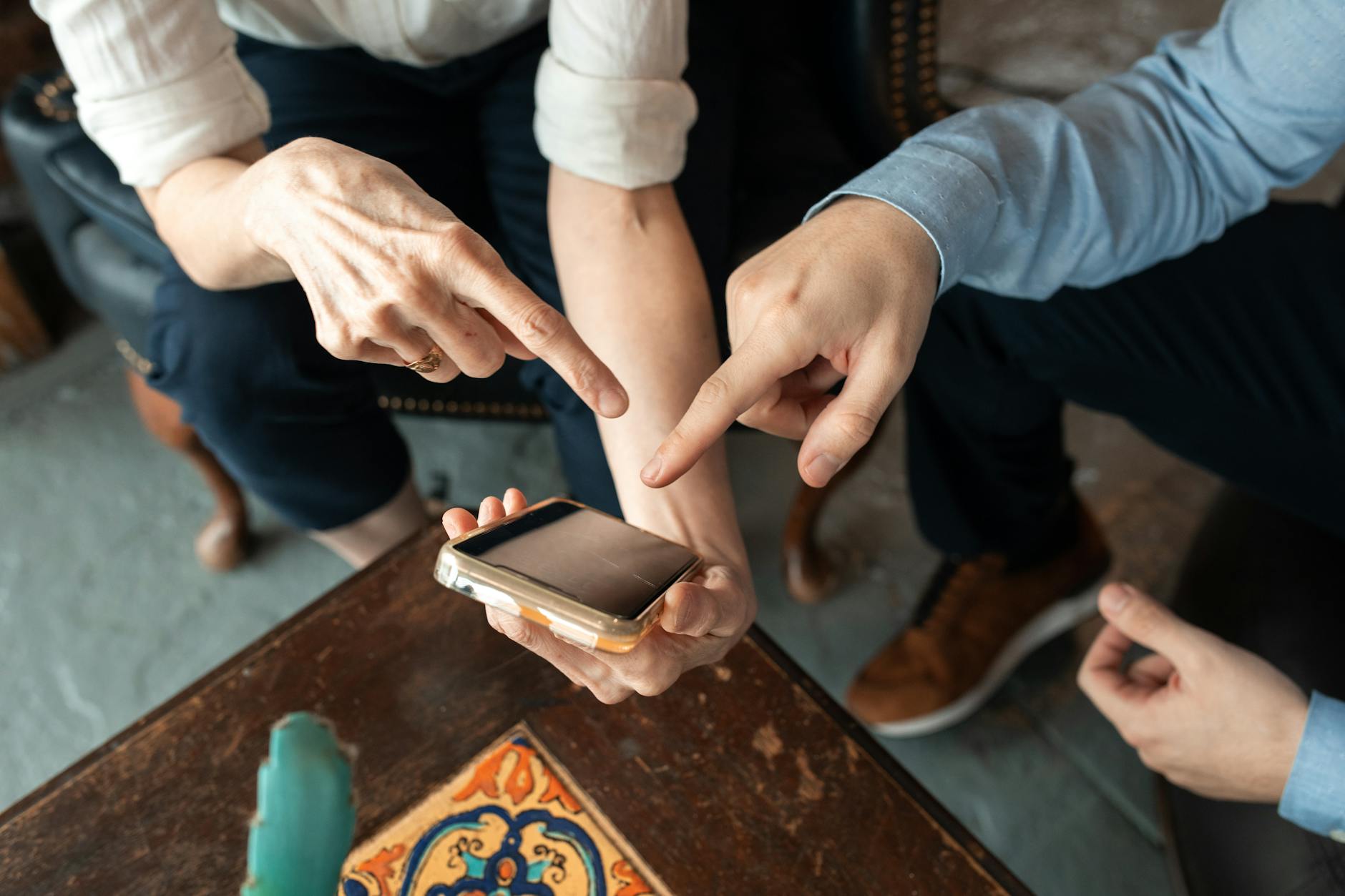 A Person Holding a Smartphone While a Man Pointing at it