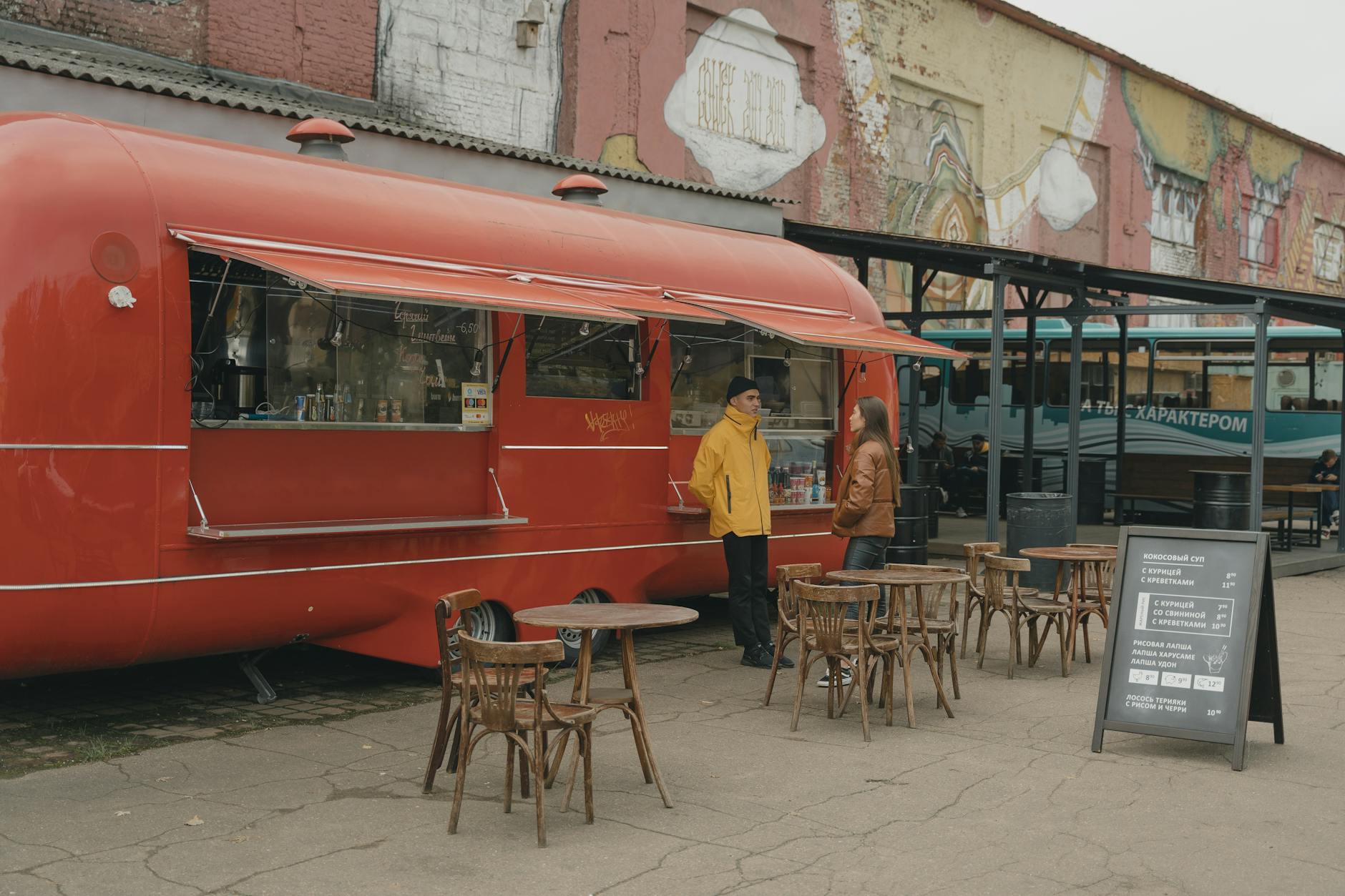 Man and Woman Standing beside Red Food Truck