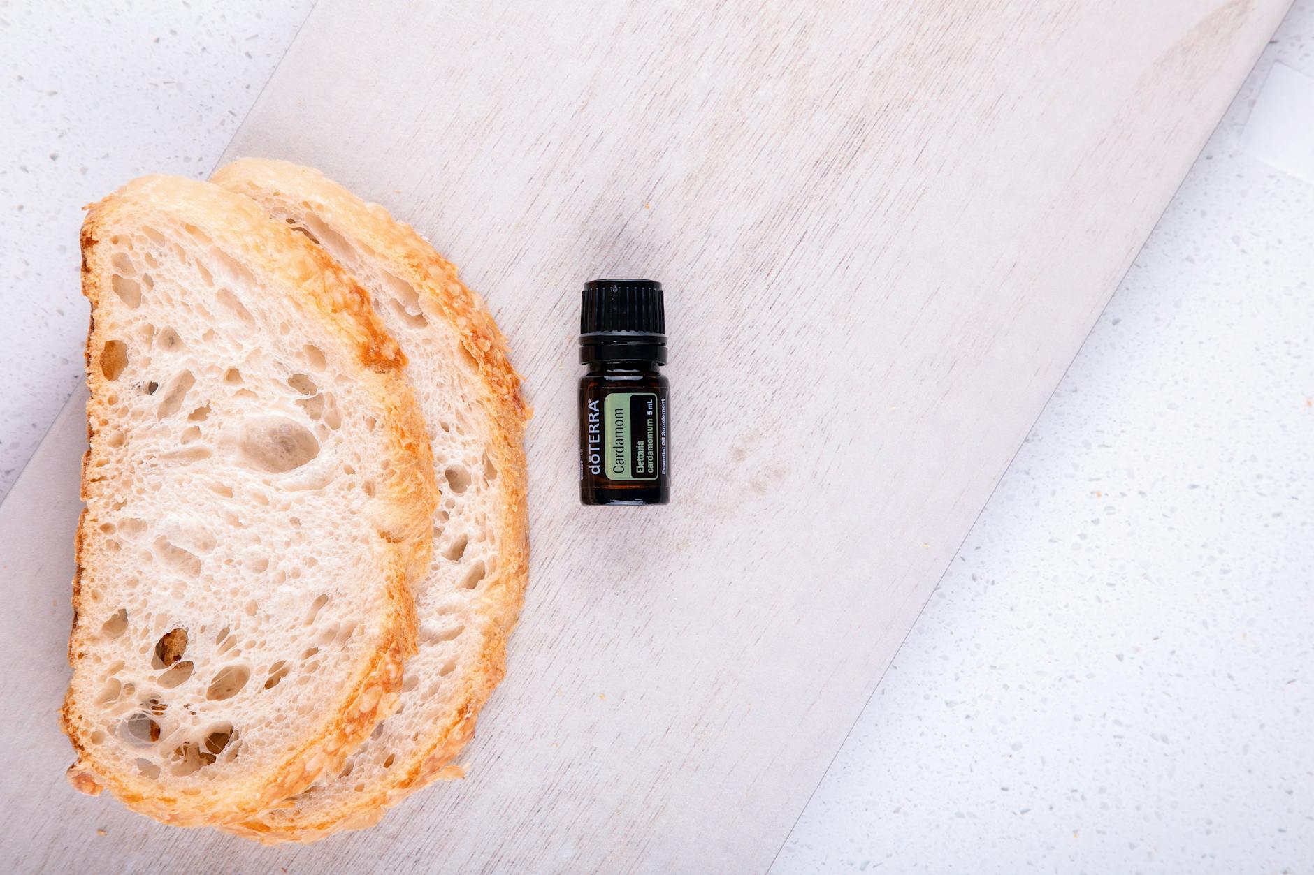 A Bottle of a Cardamom Essential Oil beside Slices of Bread