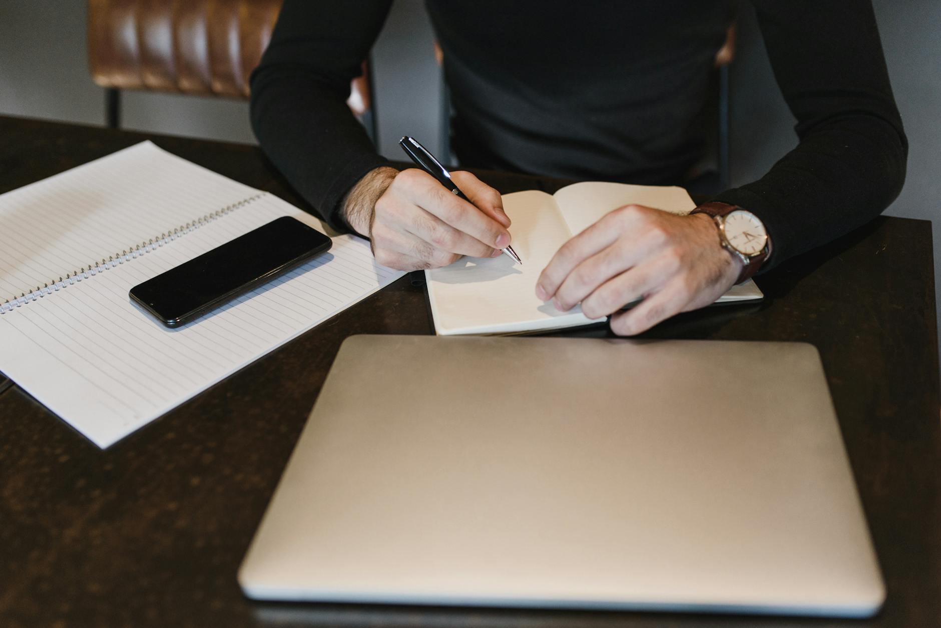 Person writing in the Notebook