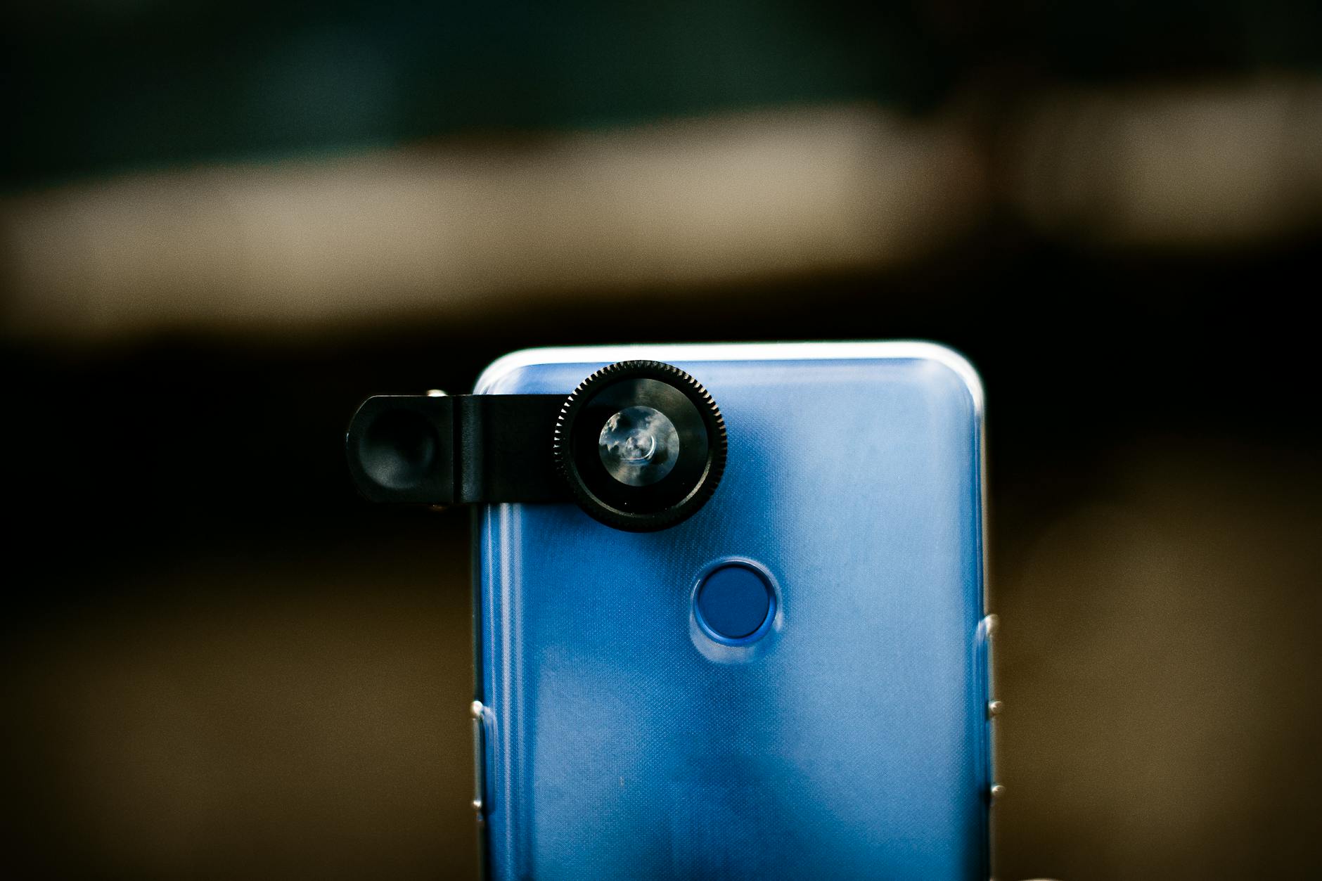 Modern mobile phone with optical lens against blurred background