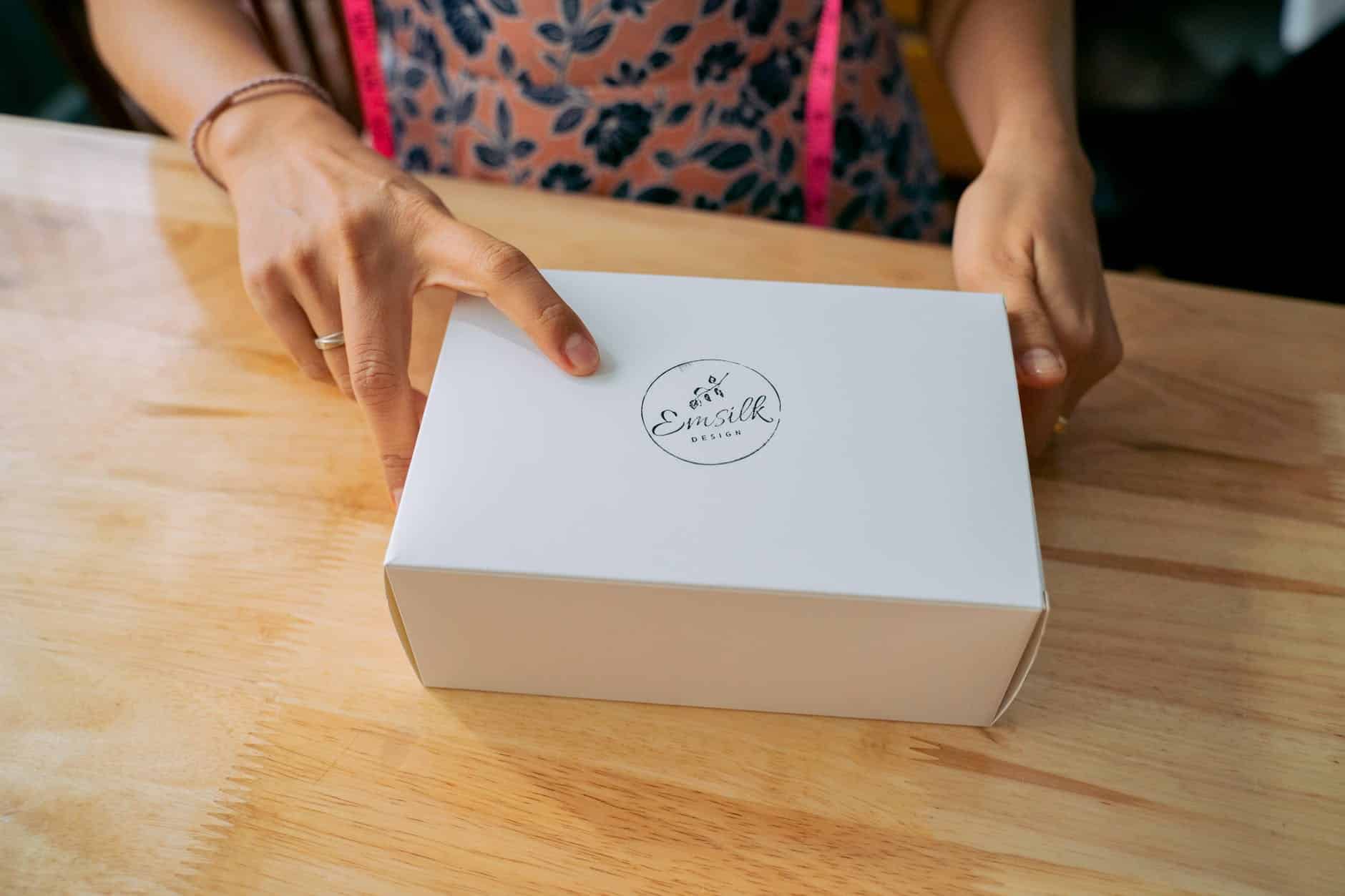A Person's Hands Holding a White Box