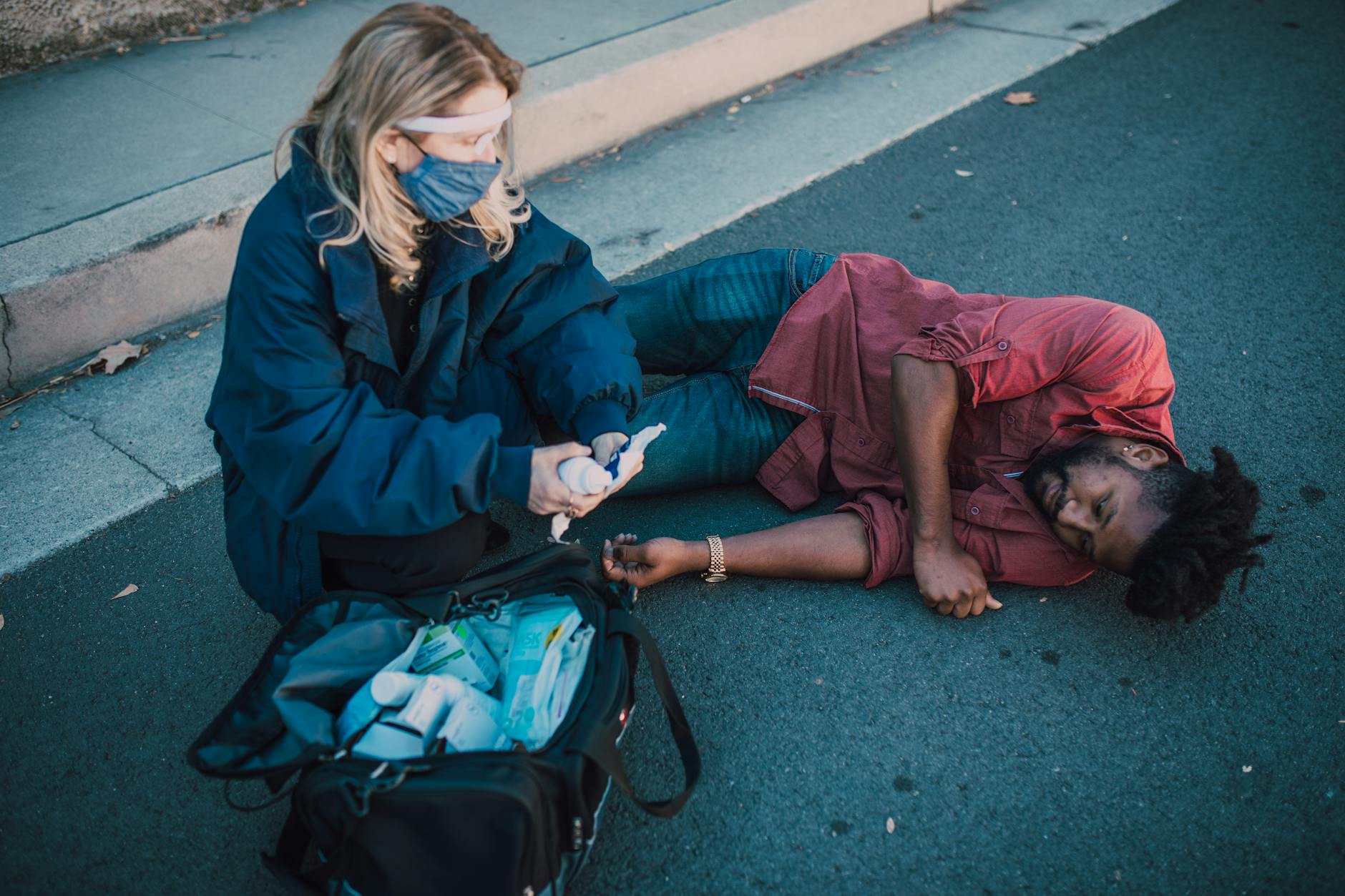 Paramedic helping a man lying on the ground