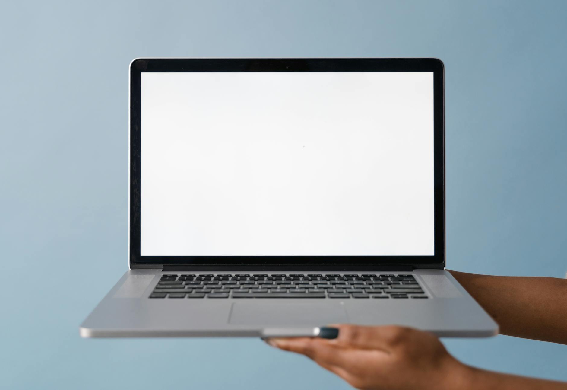 Close-Up Shot of a Person Holding a Laptop