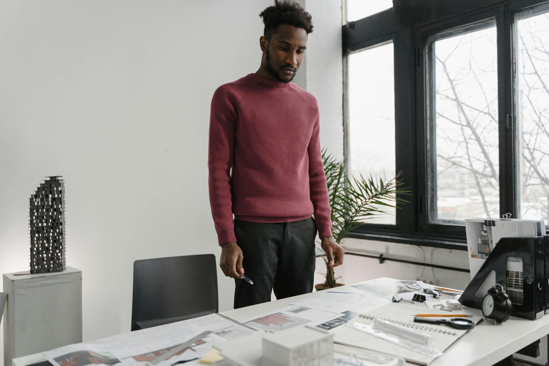 A Man Looking at His Paperworks on Table