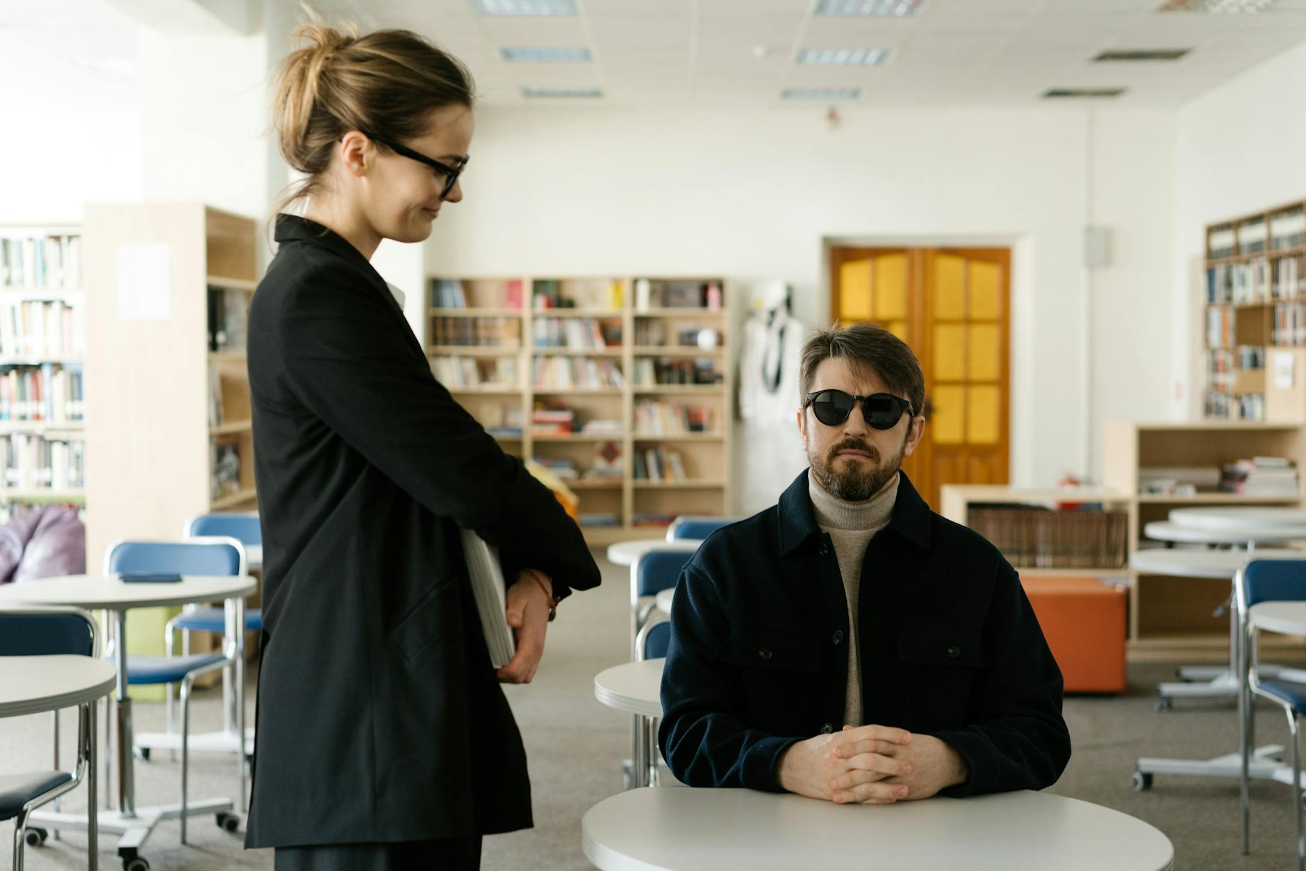 Woman in Black Coat Standing Beside White Table