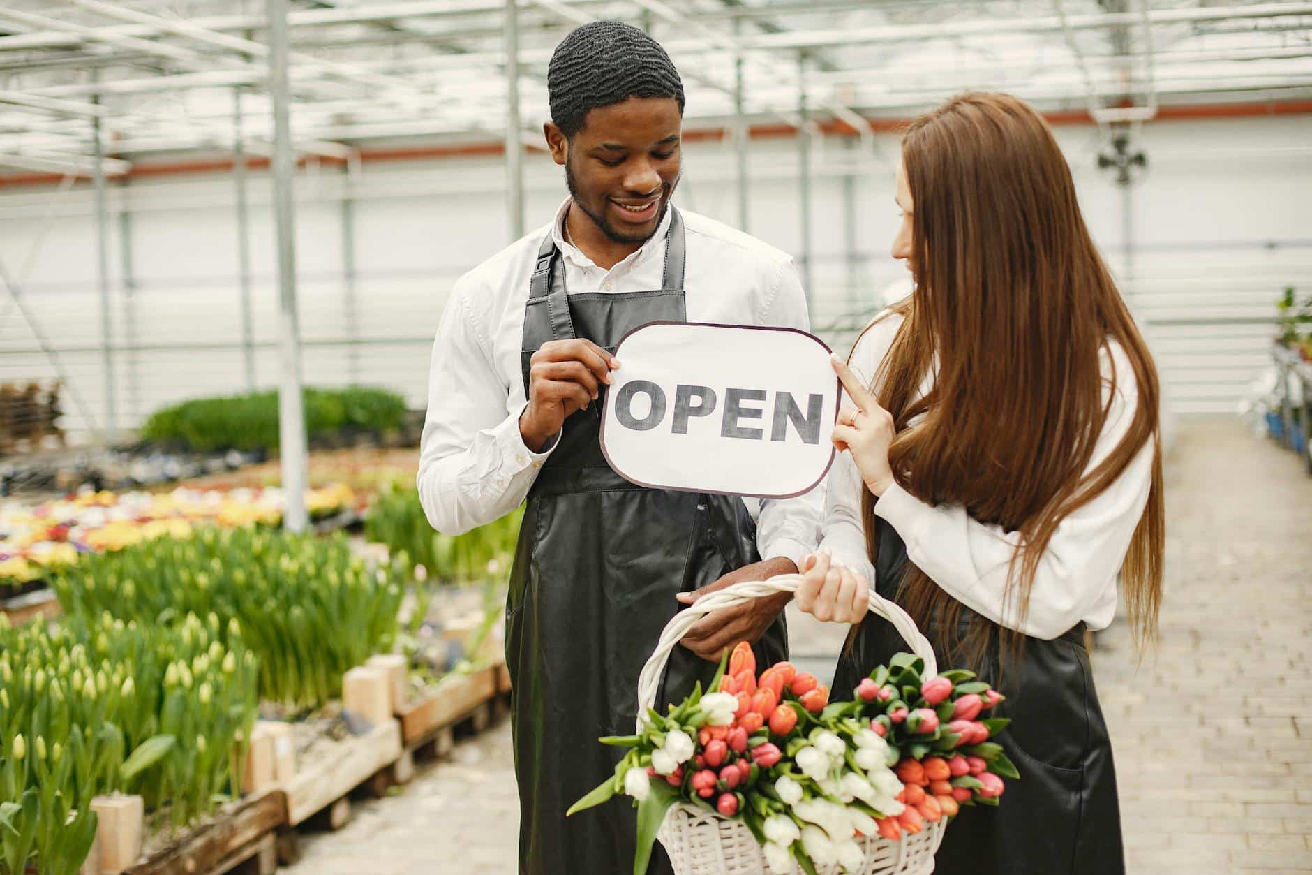 Smiling Florists Holding Open Sign