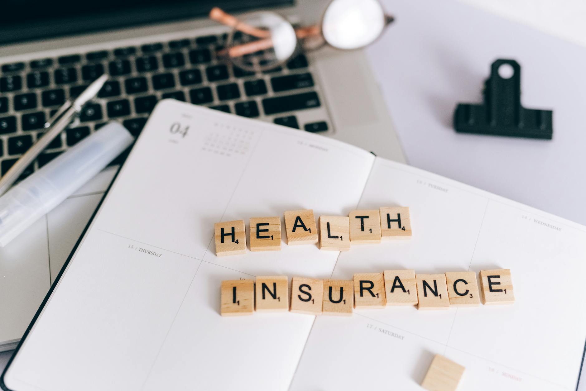 A diverse group of people gathered around a table discussing health insurance plans. Photo by Leeloo The First