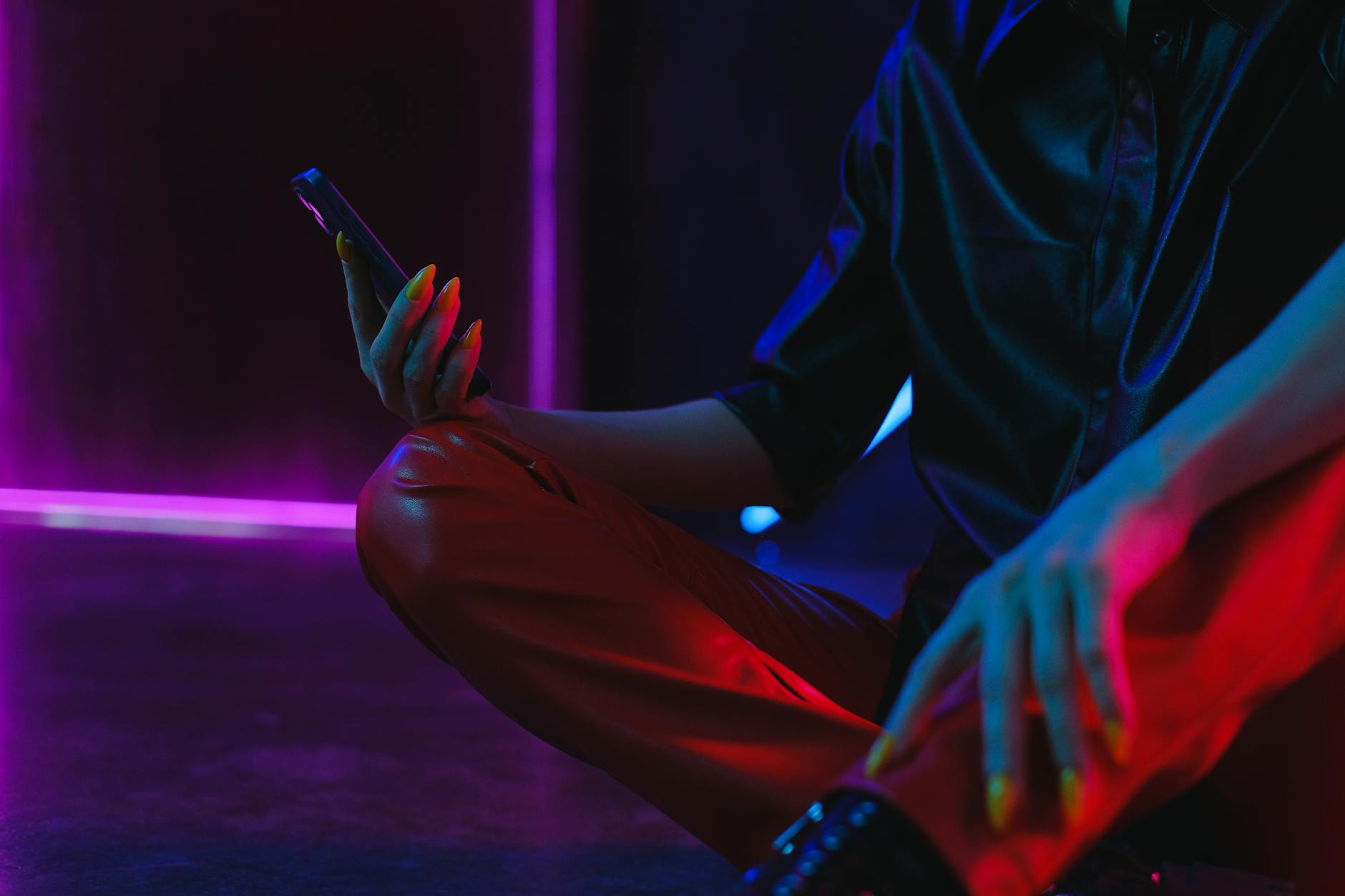 Crop unrecognizable woman using smartphone on studio floor