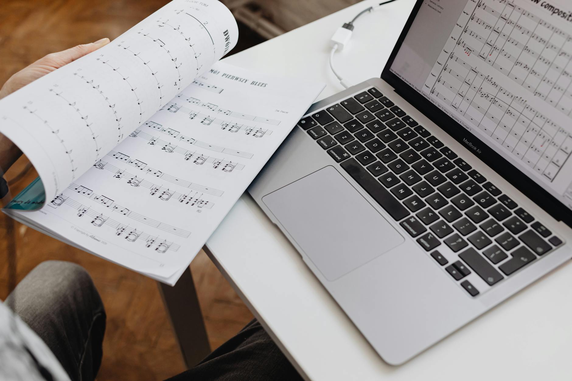 Close Up Photo of Music Book Beside a Laptop