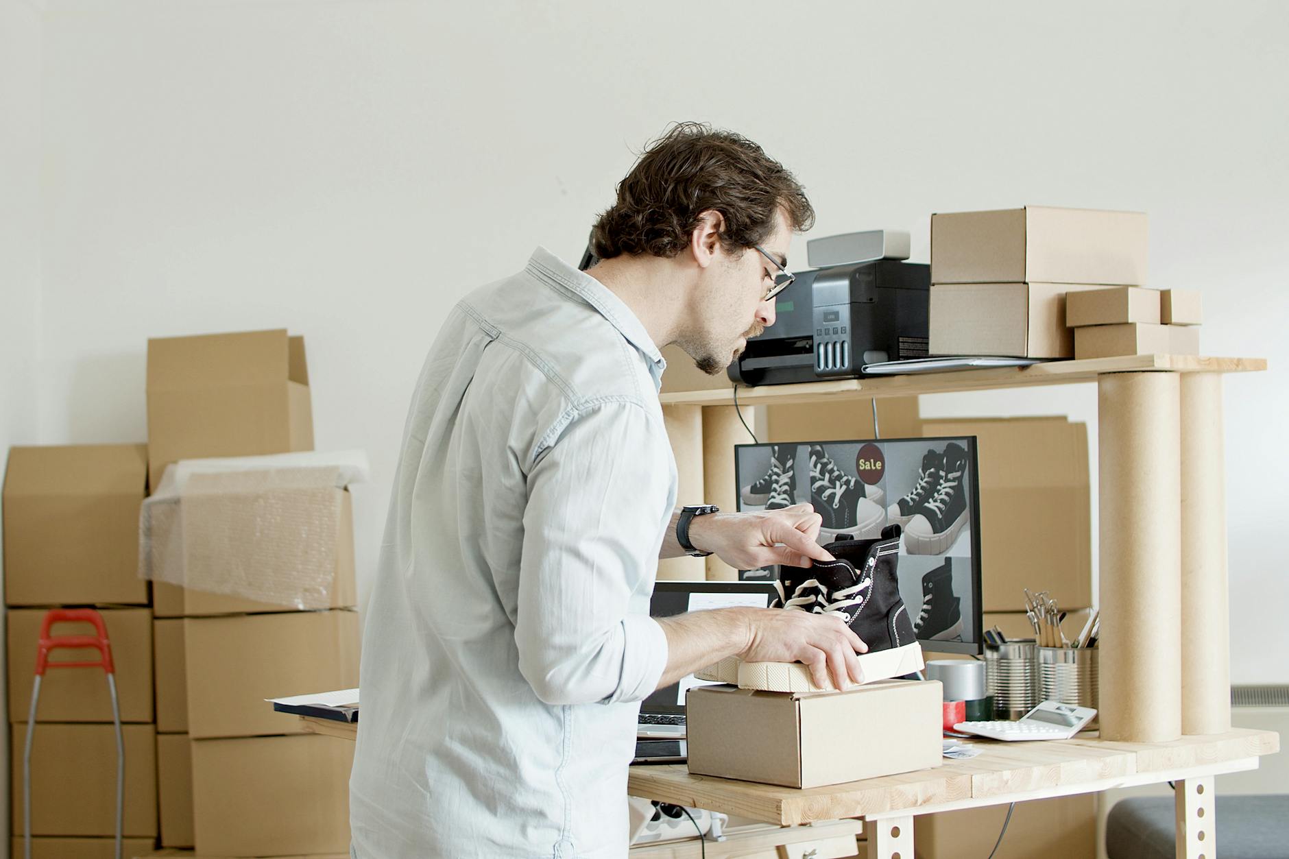 Man in Gray Dress Shirt Holding Black Shoes