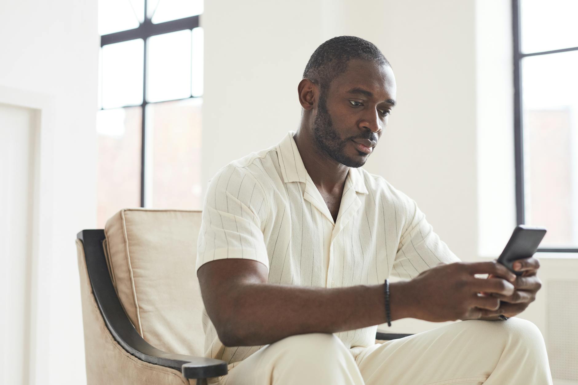 A Man Using a Cellphone while Sitting