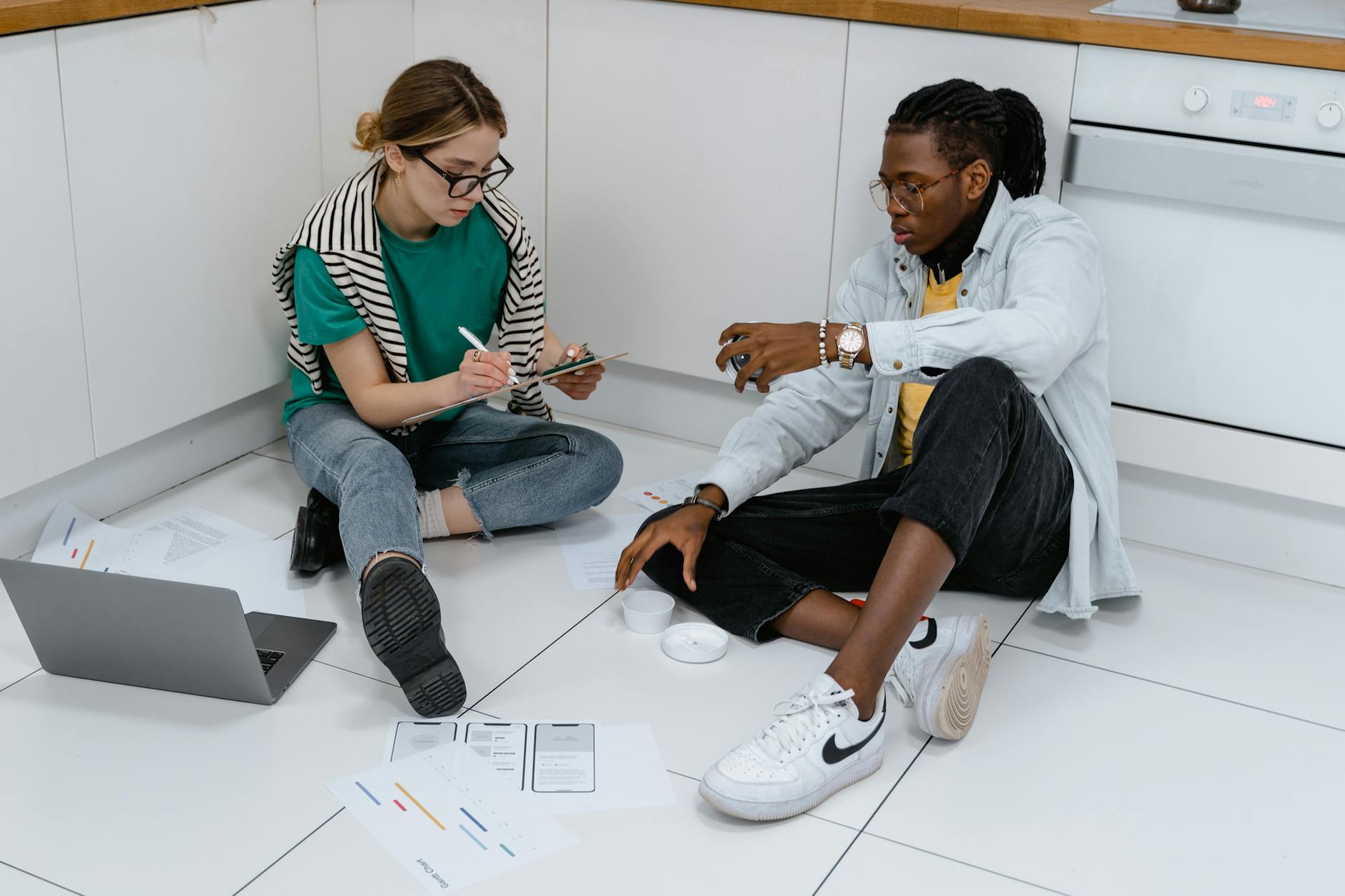 A Man and a Woman Working while Sitting on the Floor