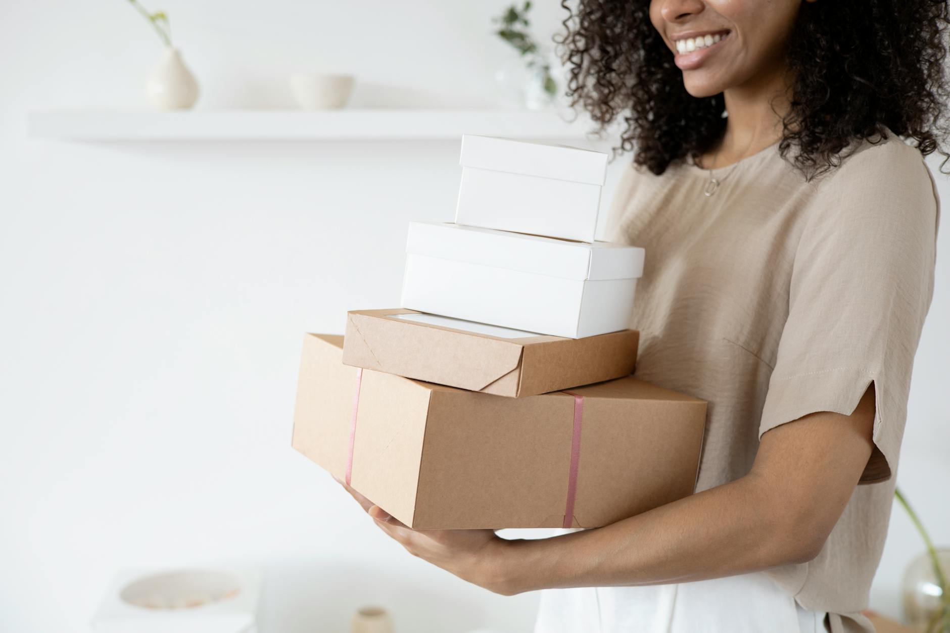 A Woman Smiling while Carrying Boxes