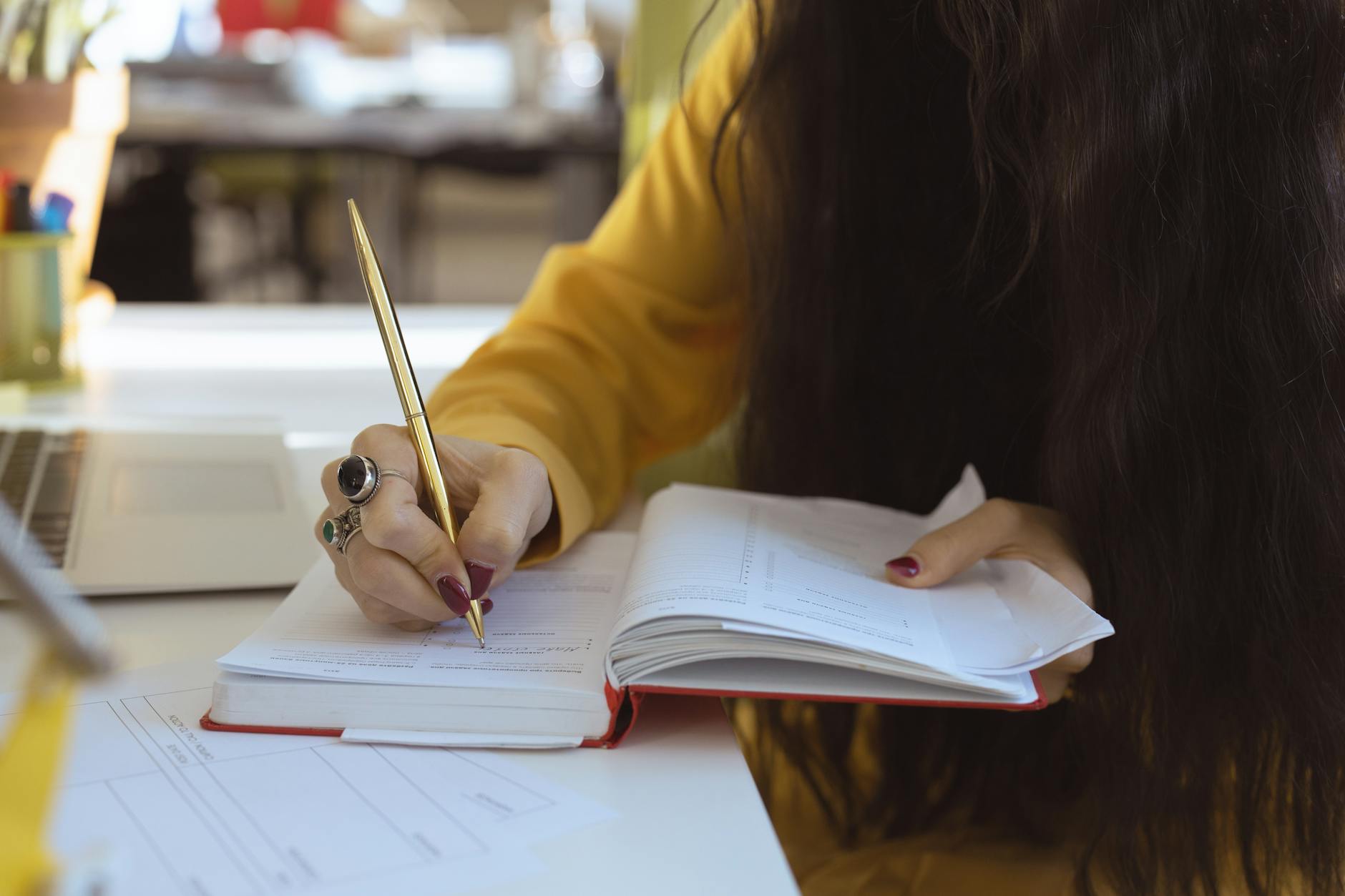 Woman With Ring Writing on a Notebook