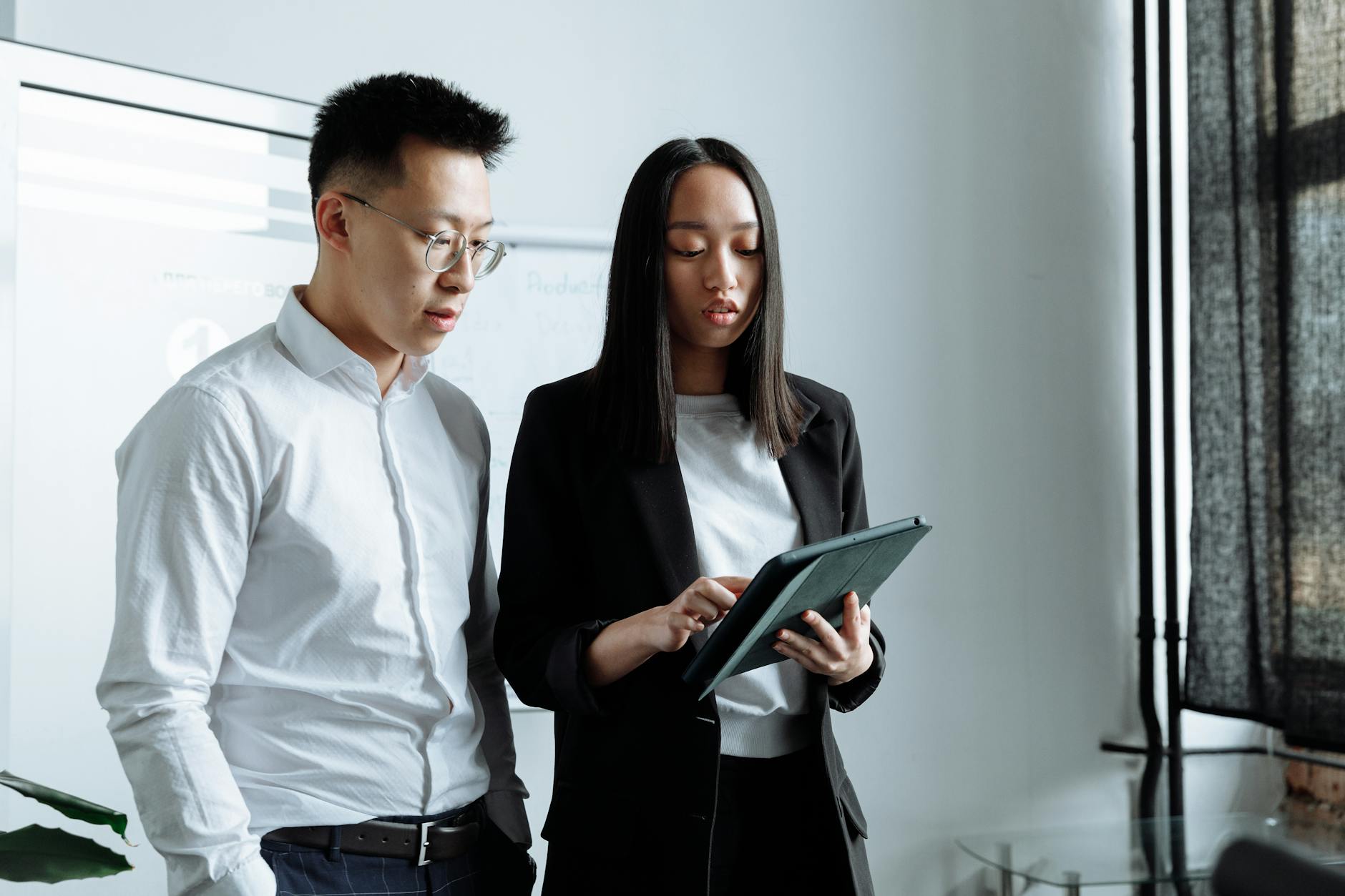 A Business Man and a Business Woman Looking at the Ipad