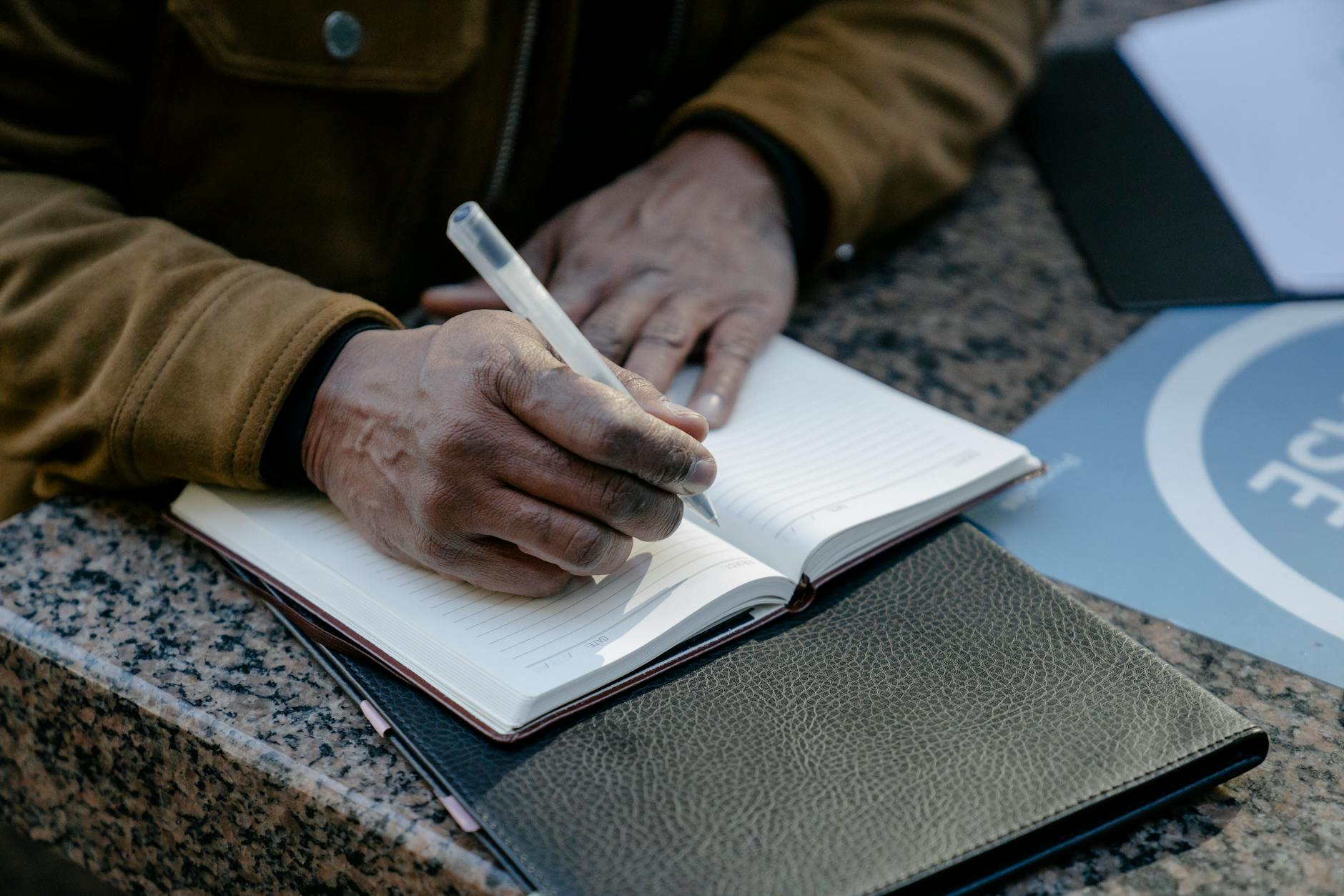 Person Writing in Notebook