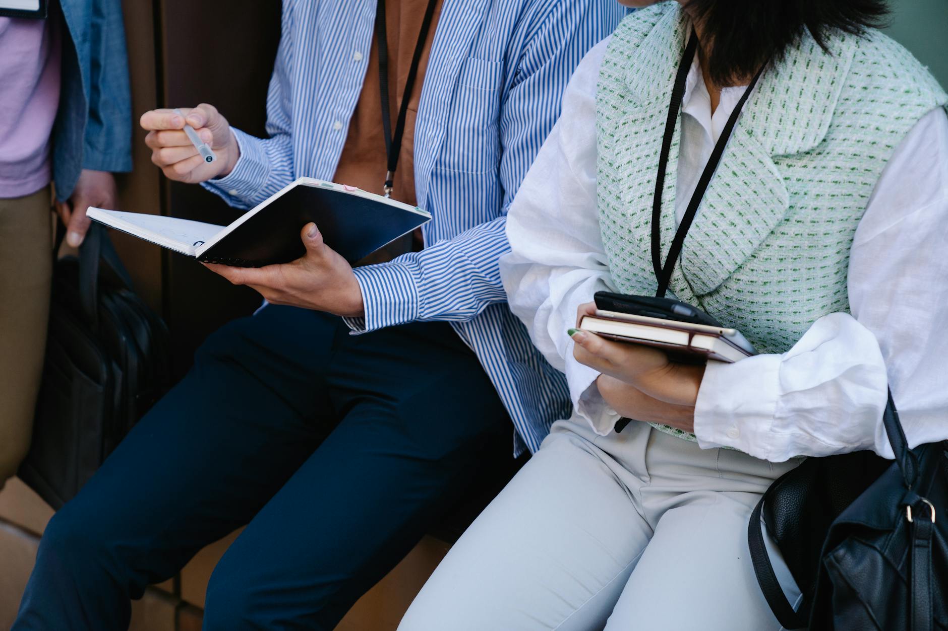 People Sitting with Notebooks