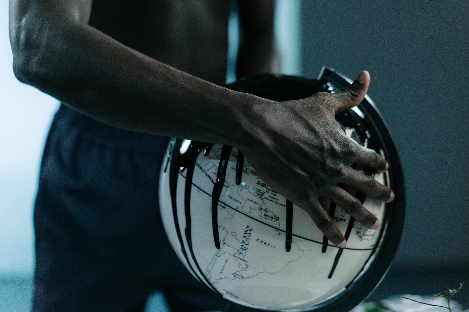 Globe Flooded with Black Goo and Covered by a Hand