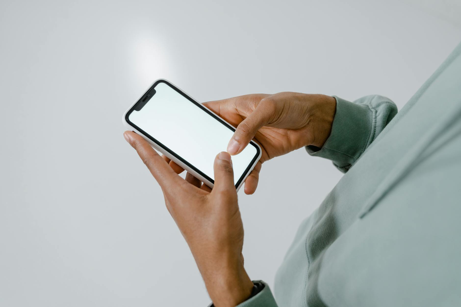 Person Holding an iPhone with Blank Screen