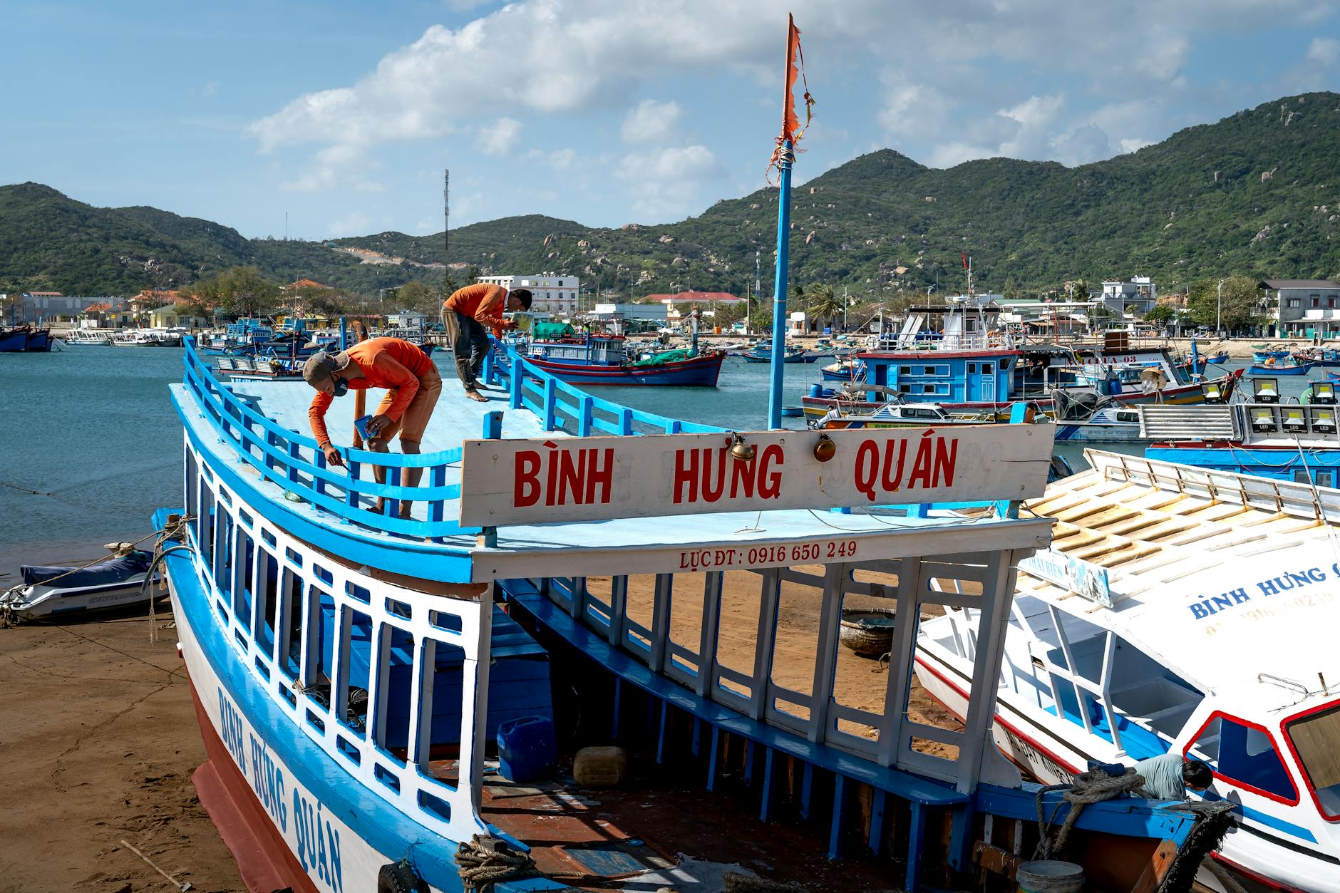 Photo of Men Painting a Boat