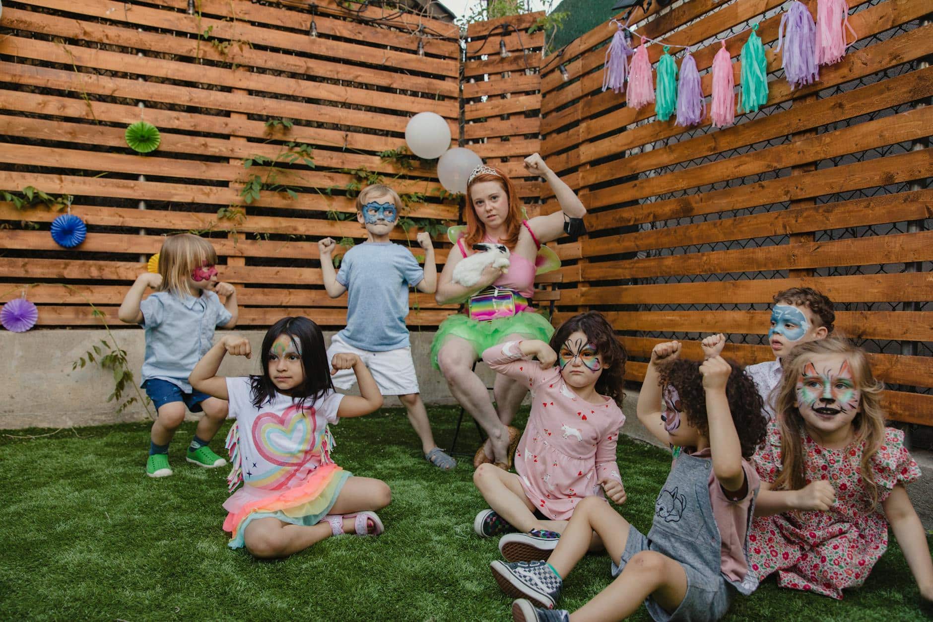 Children Sitting on Green Grass Field