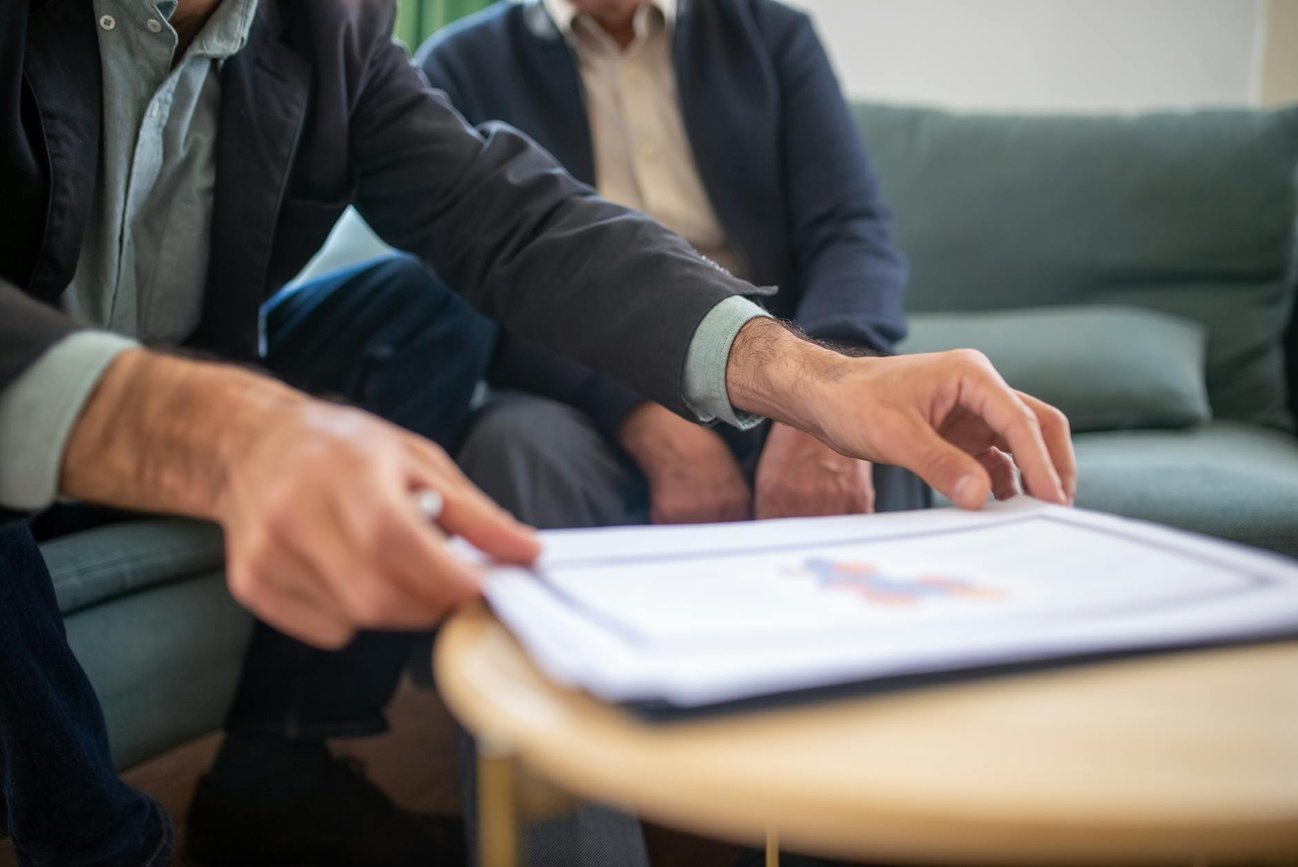 A Man Holding Documents on a Wooden Table