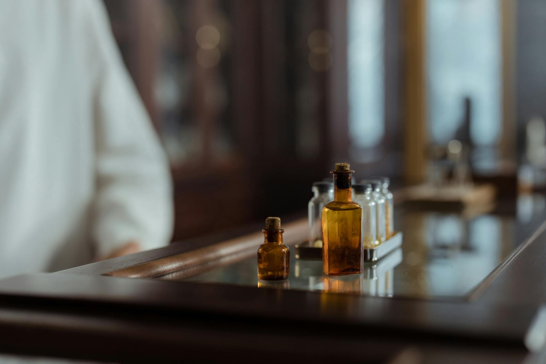 Small Brown and Clear Bottles on a Glass Surface