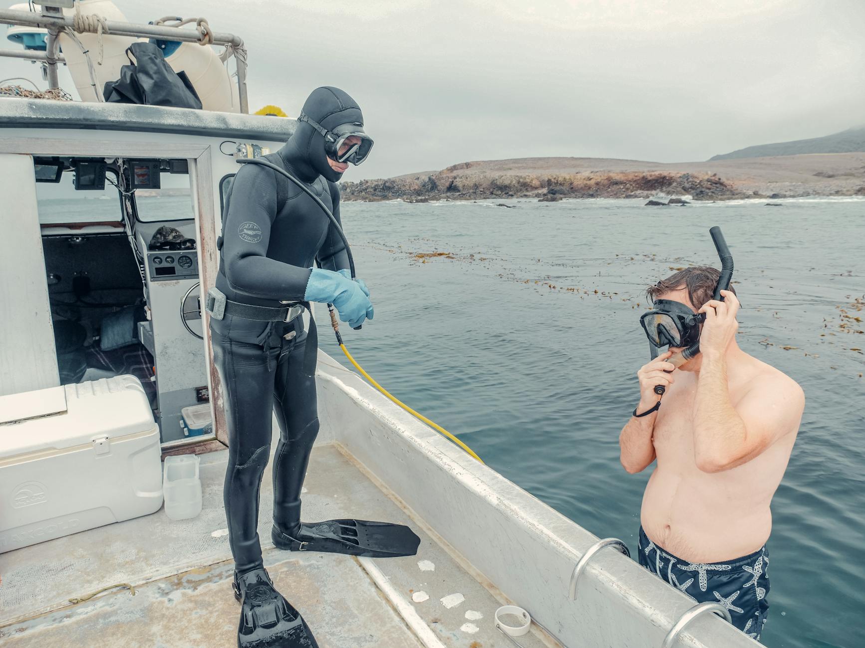 Man in Black Helmet Holding Black and Blue Stick Standing on Boat