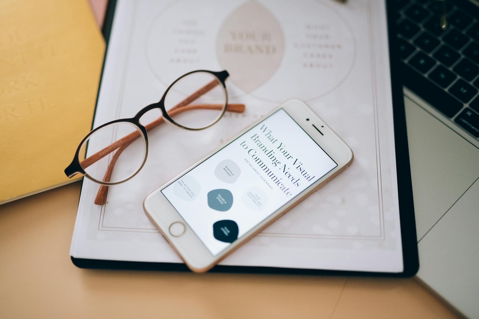 An Eyeglasses Near the Mobile Phone on White Paper