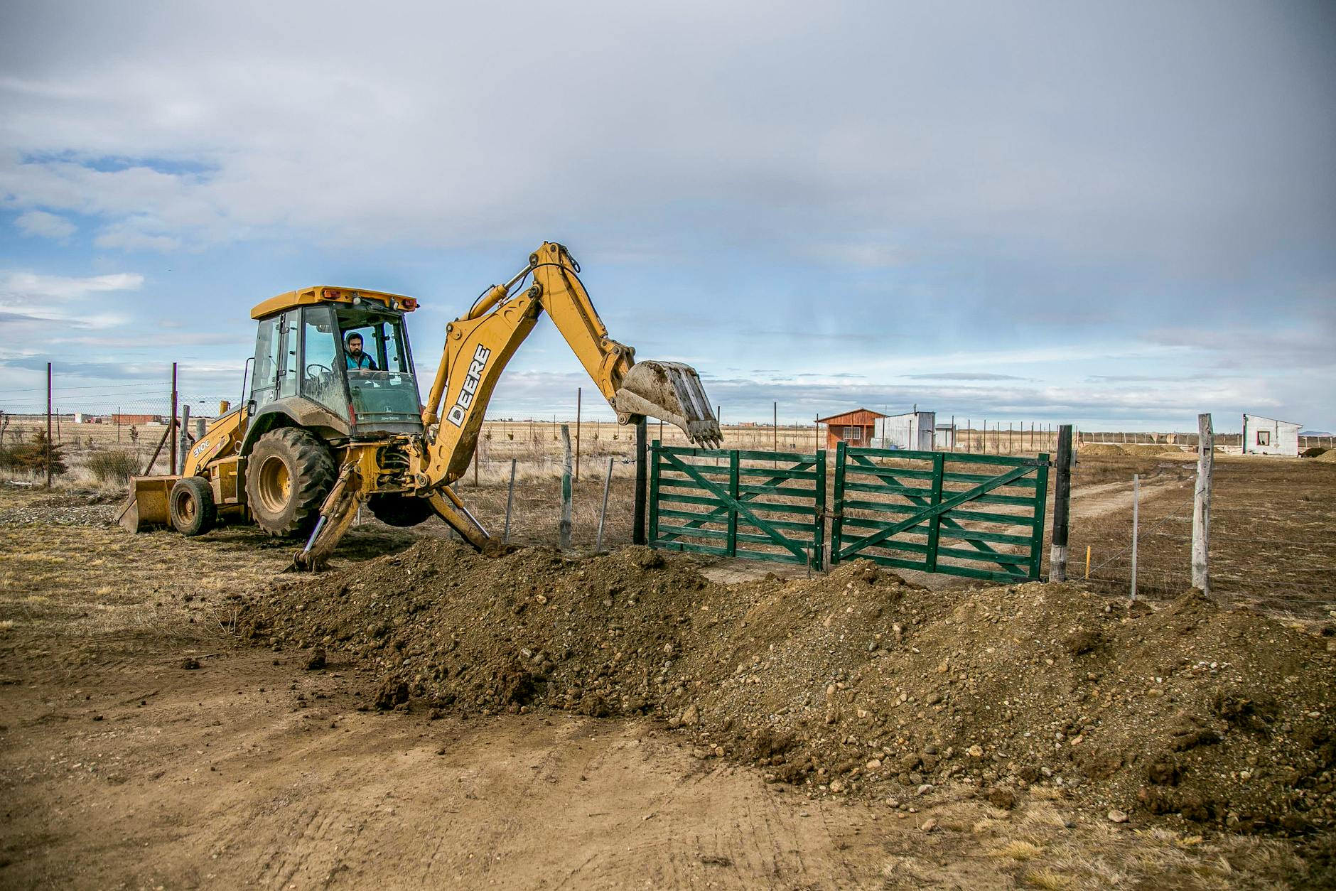 Yellow Excavator on Brown Field Under Gloomy Sky